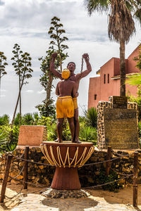 Man standing by statue against sky