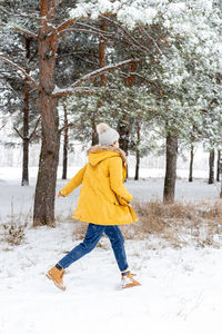 Rear view of boy on snow covered land