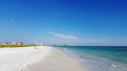 Scenic view of beach against blue sky
