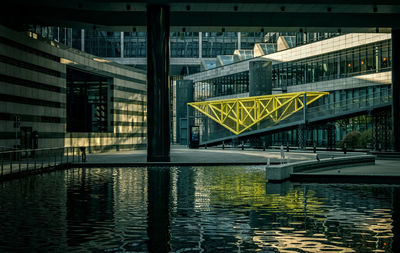 Bridge over river by buildings in city