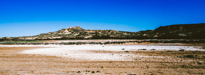 Scenic view of land against clear blue sky