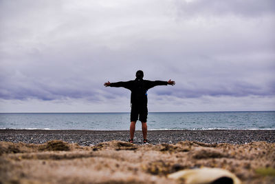 Rear view of man standing on beach