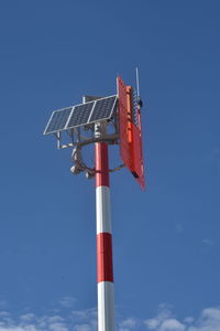 Low angle view of communications tower against blue sky