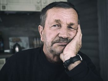 Close-up portrait of senior man sitting at home