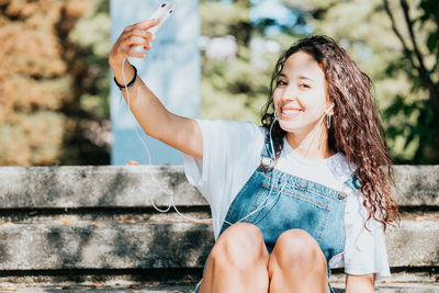 Portrait of young woman sitting on bench