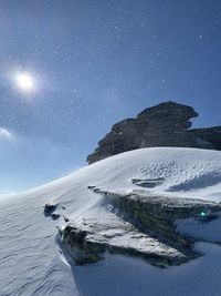 Scenic view of snowcapped mountains against sky at night