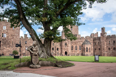 Trees in front of historical building against sky