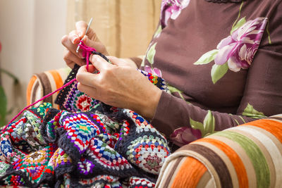 Midsection of woman holding multi colored umbrellas