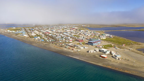 High angle view of cityscape by sea against sky