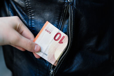 Midsection of man holding paper currency