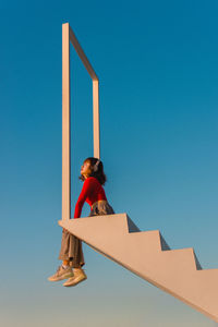 Low angle view of woman against blue sky