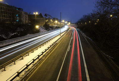 Light trails on road against sky at night