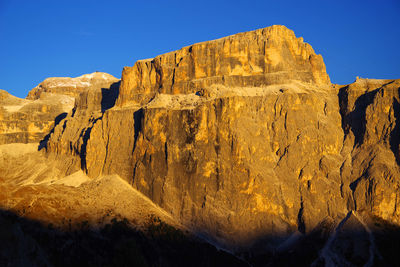 Low angle view of rock formation against clear blue sky