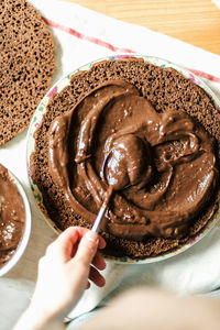 Close-up of hand holding chocolate cake