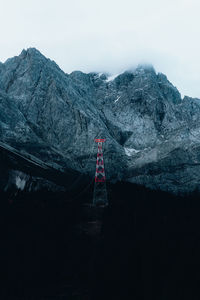 Communications tower and mountains against sky