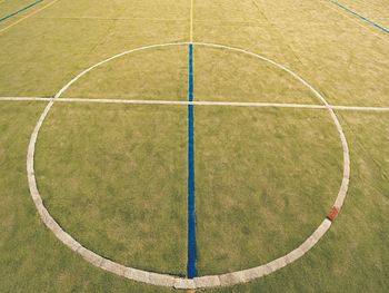 Circle in middle of court. empty outdoor handball playground, plastic light green surface, lines.