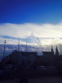 Buildings in city against cloudy sky