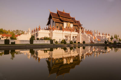 Reflection of building in lake against clear sky