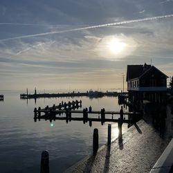 Pier over sea against sky during sunset