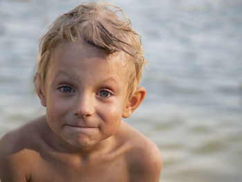 Portrait of shirtless boy at lakeshore