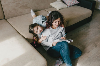 High angle view of woman sitting on sofa at home