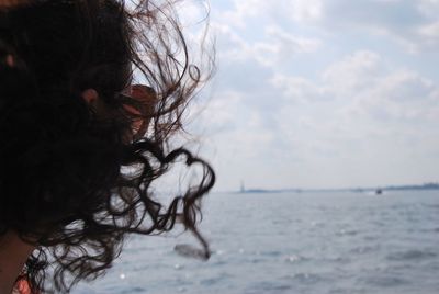 Portrait of woman by sea against sky