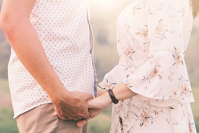 Midsection of couple holding hands