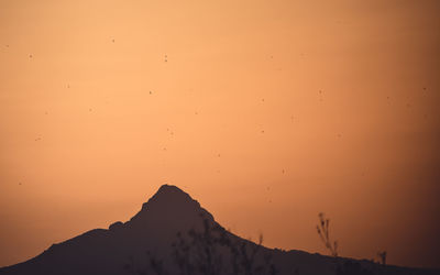 Low angle view of silhouette mountains against sky during sunset