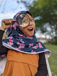 Portrait of a smiling young woman and magnifying glass