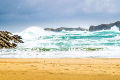 Scenic view of rocks in sea against sky