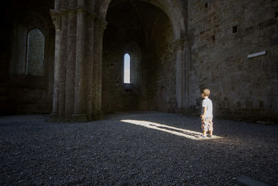 Side view of boy standing at historic building