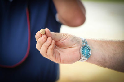 Cropped hand of man holding dried fruit