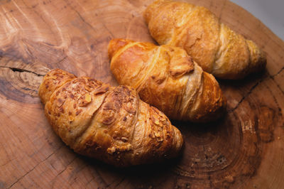 Three freshly baked croissant on a wooden tray. delicious and healthy breakfast
