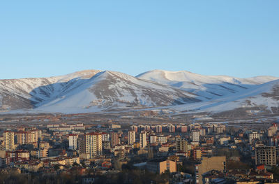 Aerial view of snowcapped mountains against clear blue sky