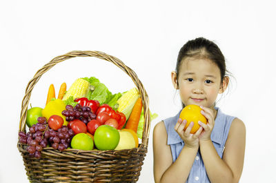Portrait of girl holding fruits in basket