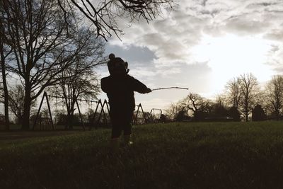 Boy playing on grass against sky