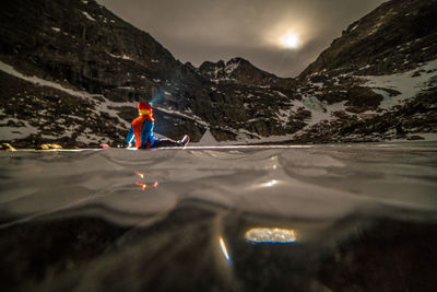 Man on mountain against sky during winter