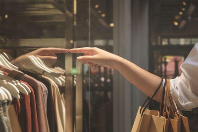 Midsection of woman holding umbrella at store