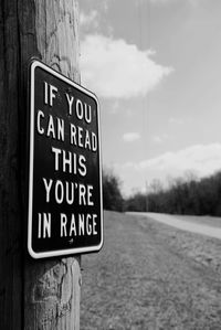 Road sign against cloudy sky