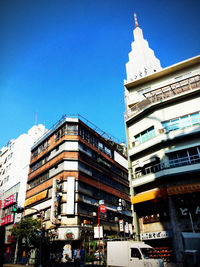 Low angle view of buildings against clear blue sky