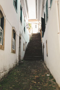 Footpath leading towards steps amidst buildings