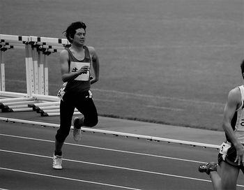 Full length of young man running on sports track