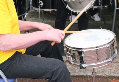 Midsection of man playing drum during event