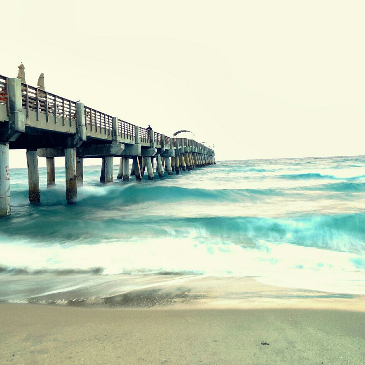 sea, water, beach, horizon over water, wave, clear sky, shore, surf, sand, copy space, scenics, beauty in nature, tranquil scene, built structure, nature, tranquility, pier, motion, sky, idyllic