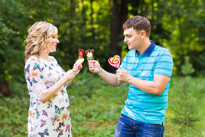 Woman holding ice cream standing outdoors