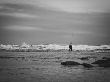 Man standing on beach against sky