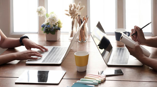 Midsection of woman using smart phone on table