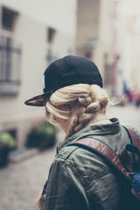 Rear view of woman with umbrella in city