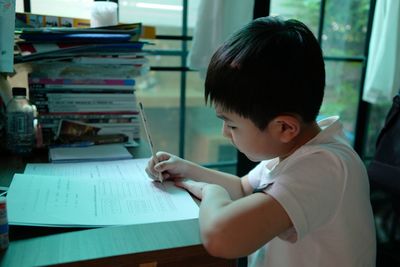 Portrait of boy with book on table