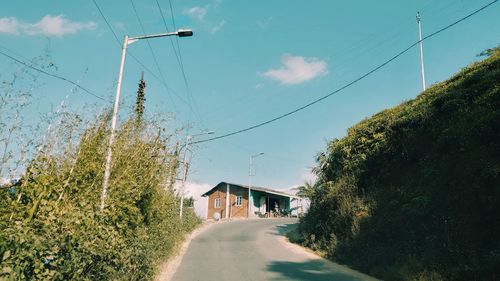 Road amidst trees against sky
